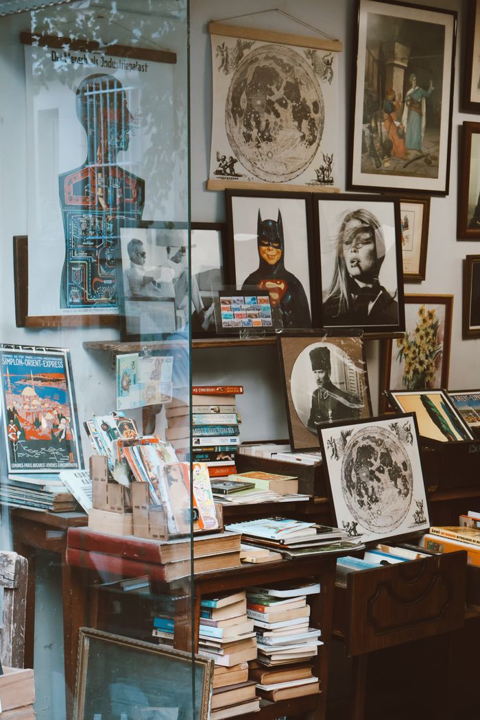 Vintage bookstore window display featuring art, comics, and collectibles.